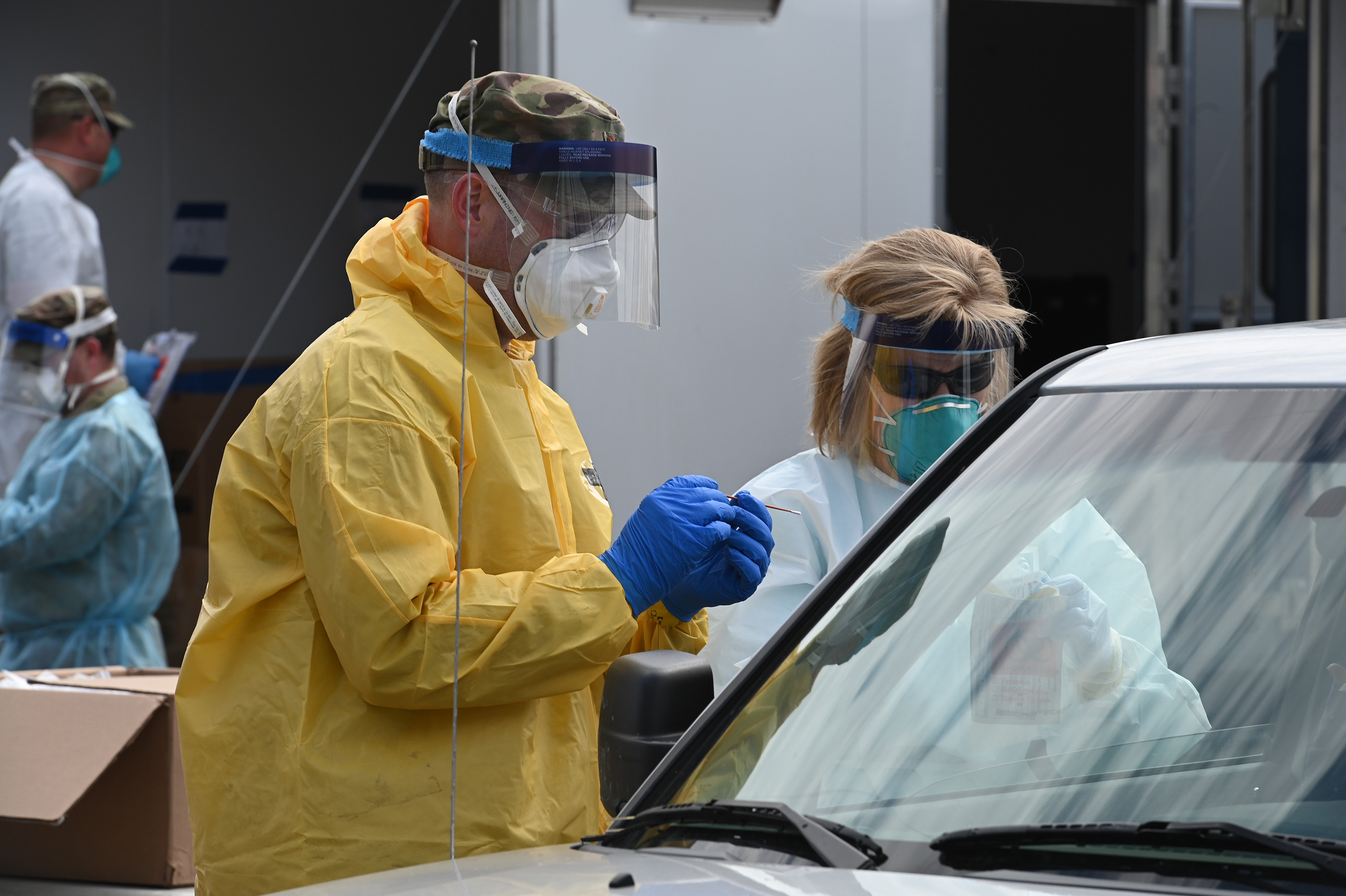 Maj. Chad Brooks, of the 119th Medical Group, left, and Julie Hardy, a registered nurse working with the North Dakota Department of Health, collect a COVID-19 testing swab from a volunteer testing participant in the parking lot of the Alerus Center, Grand Forks, N.D., April 23, 2020. They are wearing personal protective equipment (PPE) to stay safe while they work and help prevent the spread of the Coronavirus while testing people as they drive through the process in their vehicles. He is just one of the many N.D. National Guard members partnering with the N.D. Department of Health and other civilian agencies in support of the whole community response to the COVID-19 pandemic. Approximately 700 people were tested in the five-hour testing event April 23. (U.S. Air National Guard photo by David H. Lipp)